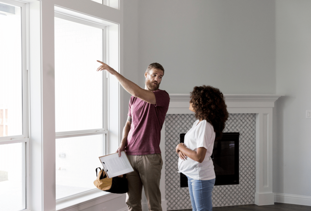 home inspector pointing at windows, standing next to homeowner