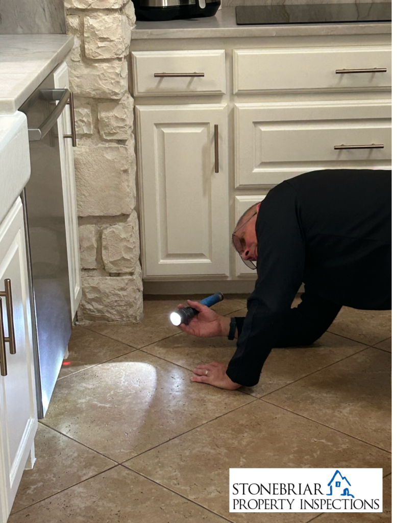 Stonebriar Property Inspections inspector inspecting under dishwasher